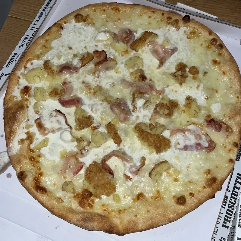 Pizza bianca con pancetta e crumble croccante, nel cartone da asporto