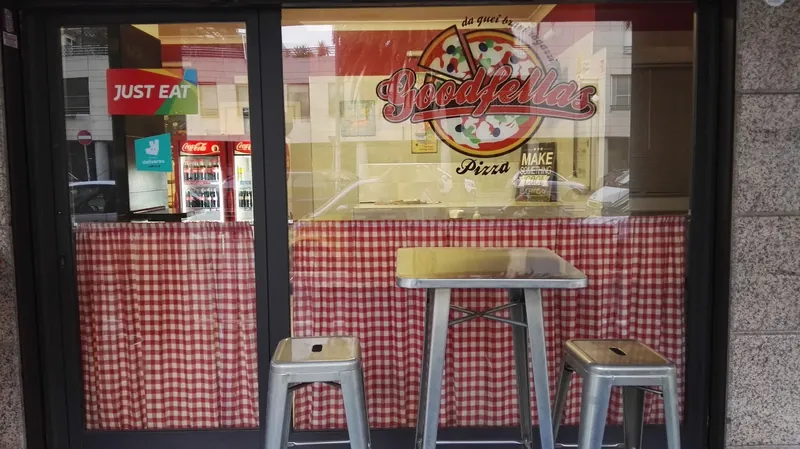 La vetrina di GoodFellas con il logo, le tende a quadretti rossi e gli sgabelli in metallo